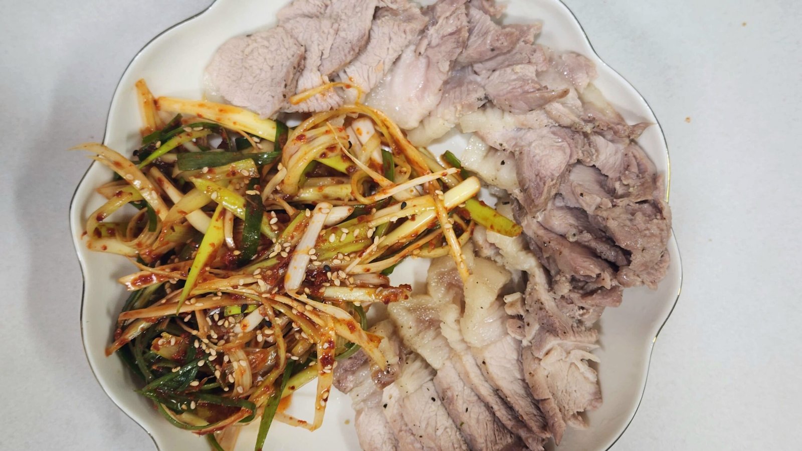 Tender sliced Korean boiled pork belly suyuk served over sweet steamed onions