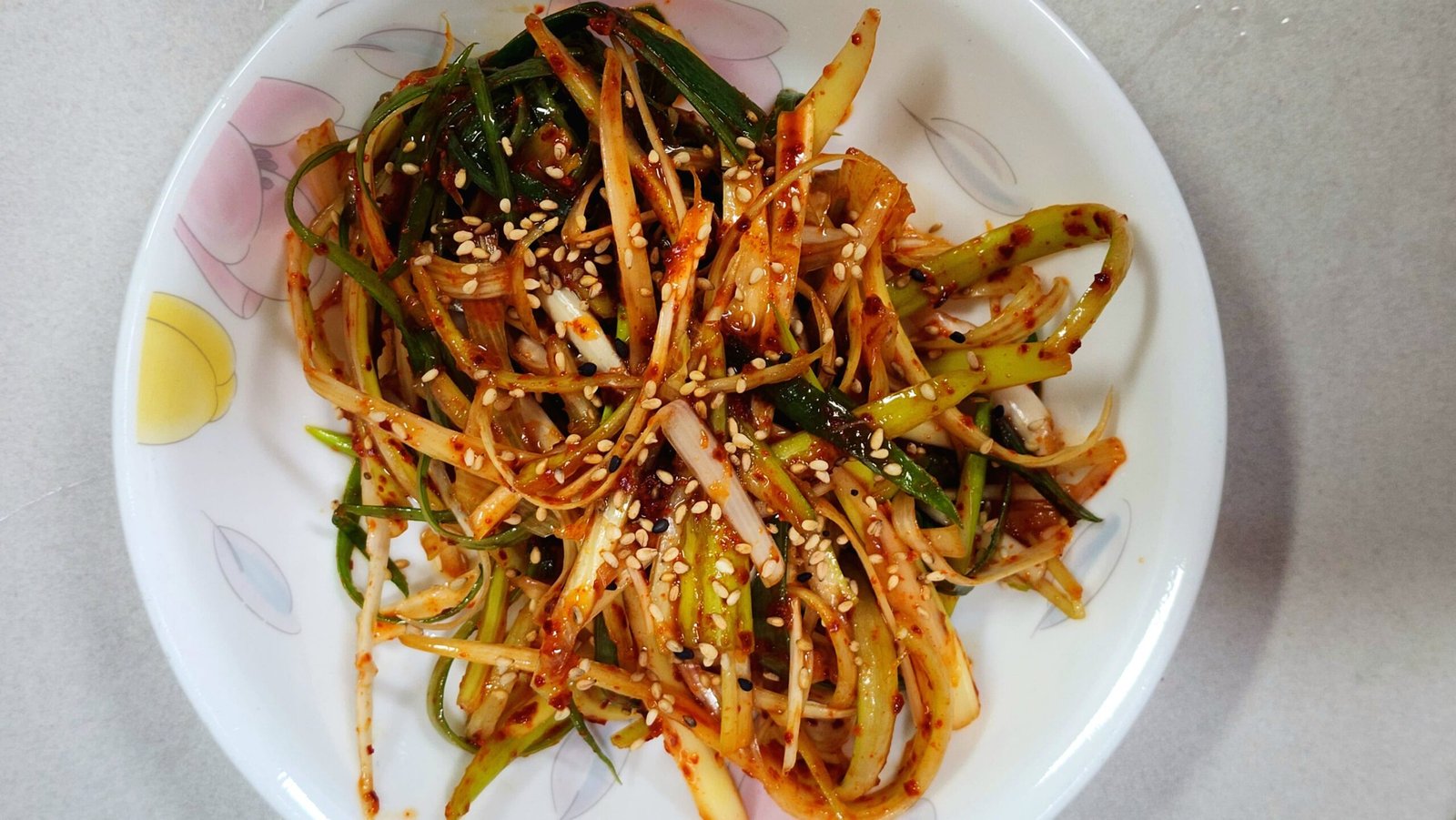 Fresh Korean green scallion salad pajeori garnished with toasted sesame seeds