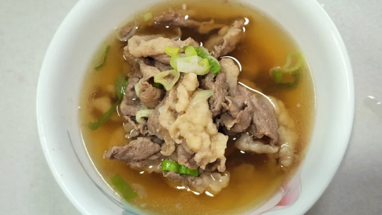 A warm bowl of 10-minute shortcut Korean beef soup galbitang topped with sliced green onions and black pepper