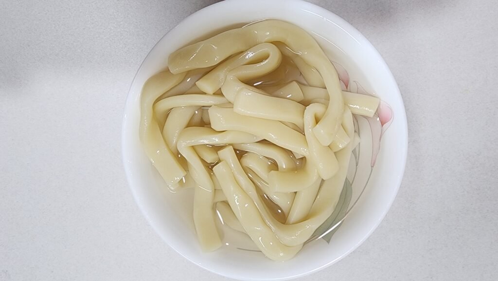 Soaking Korean tteok rice cakes in a bowl of cold water