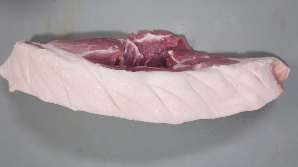 Scoring pork belly fat in a crosshatch pattern for microwave suyuk