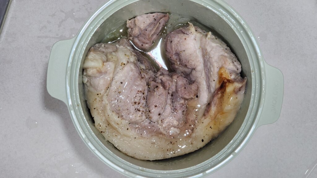 Fully cooked, tender pork belly in a microwave-safe dish after 10 minutes of steaming