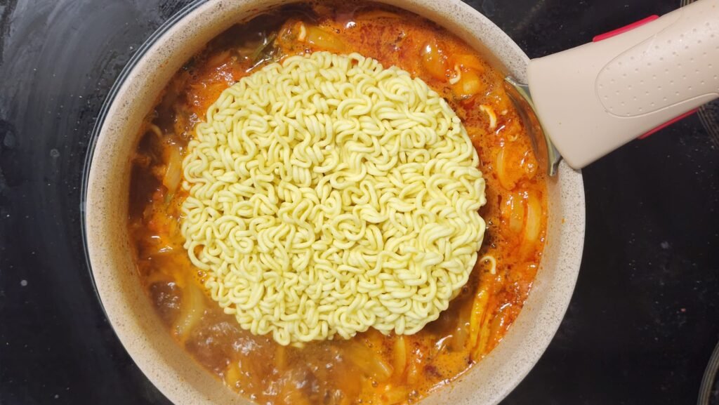 Adding Shin Ramyun noodles once the broth comes to a boil.
