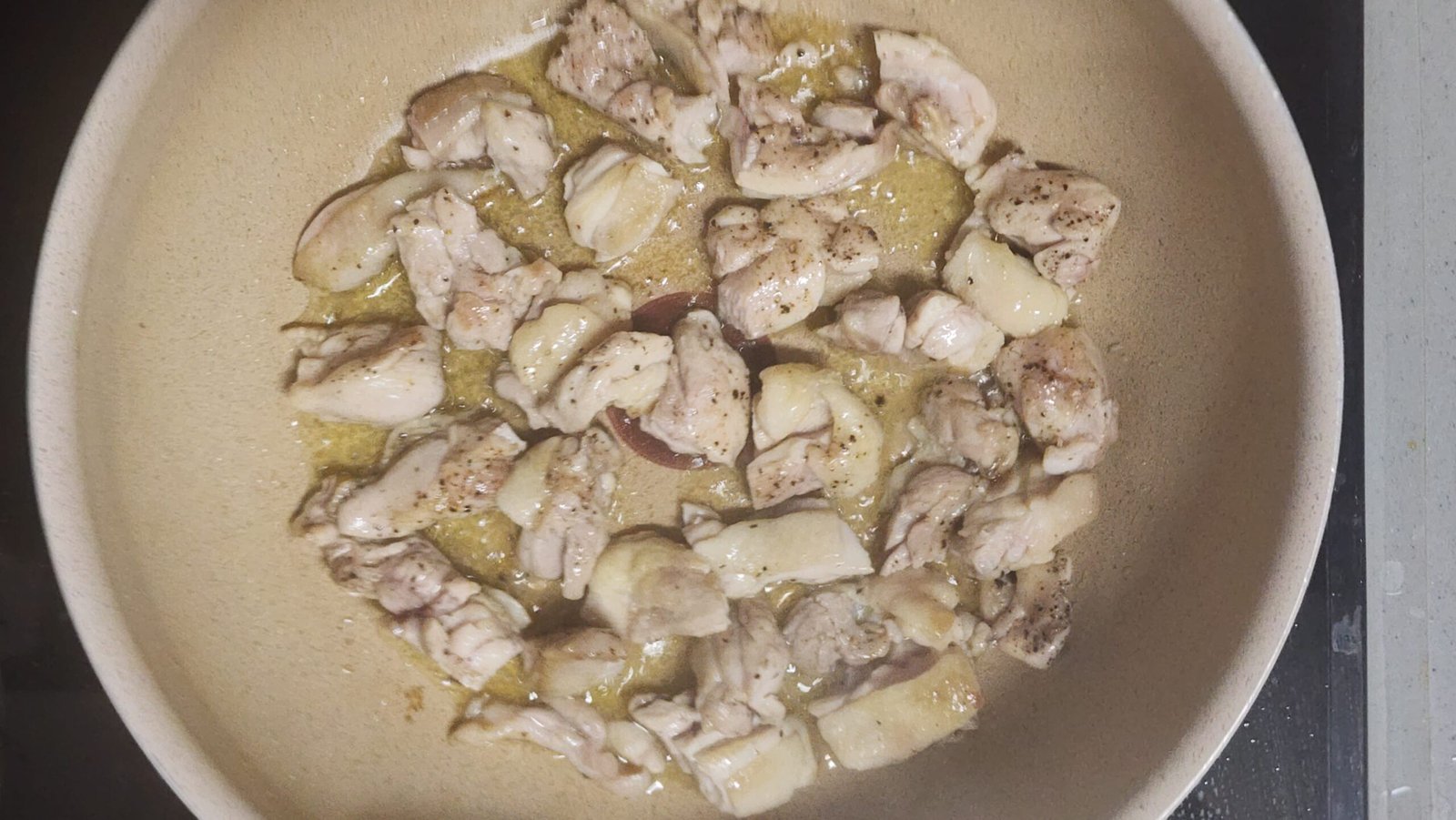 Cutting into the chicken thigh with kitchen scissors to check the inside while it is partially cooked.