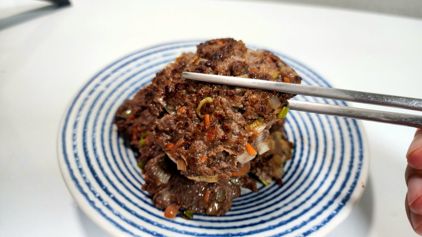 Cooked tteokgalbi patties served on a plate.