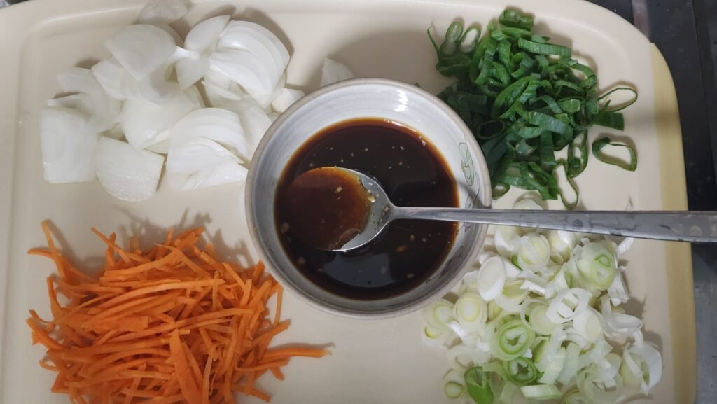 Mixing soy sauce, oyster sauce, sugar, cooking wine, Korean pear drink, minced garlic, and black pepper.