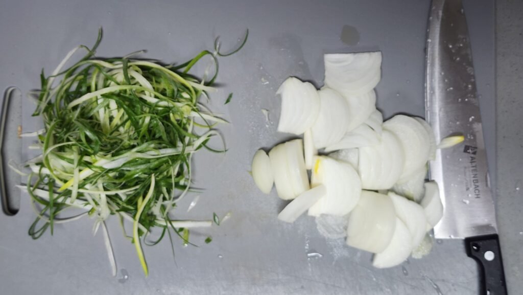Thinly sliced Korean green onion and onion prepared for spicy Shin Ramyun.
